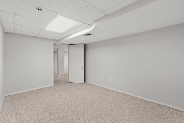 empty room with visible vents, carpet flooring, a paneled ceiling, and baseboards