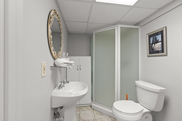 full bathroom featuring tile patterned floors, a drop ceiling, a shower stall, and toilet