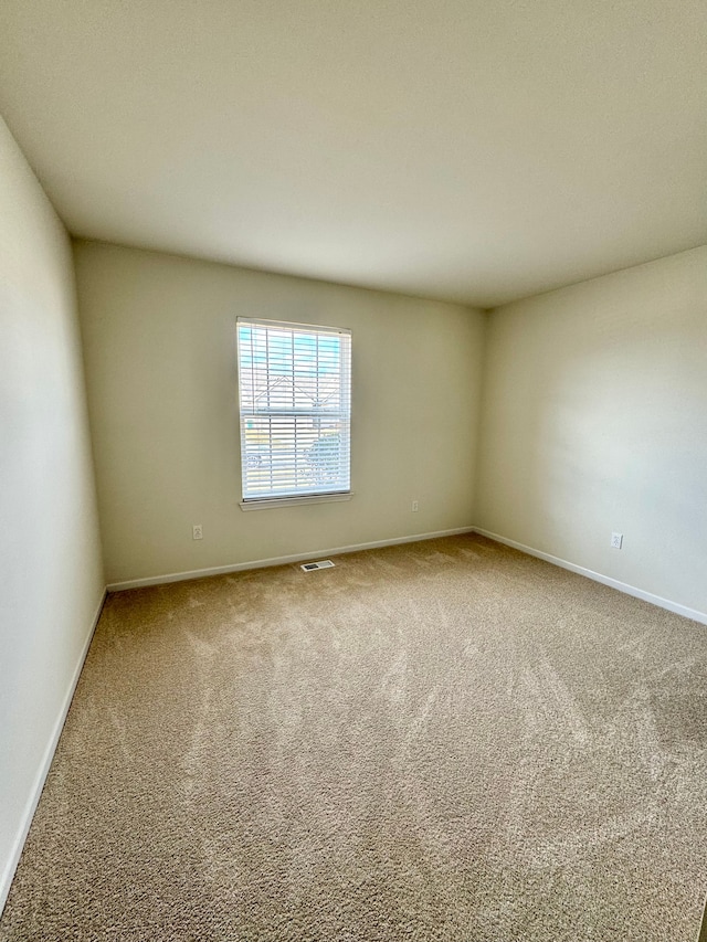 unfurnished room with visible vents, baseboards, and carpet