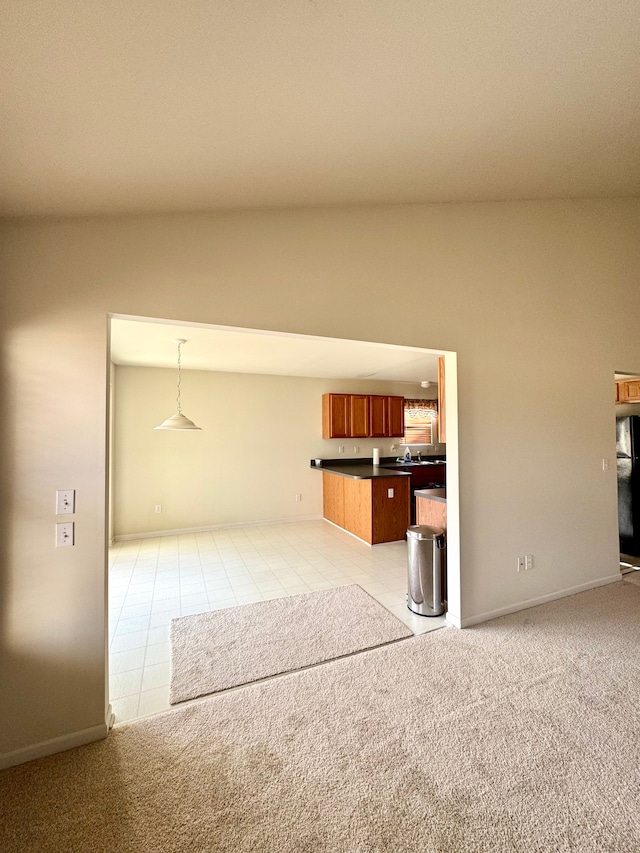 unfurnished living room featuring light tile patterned floors, light colored carpet, and vaulted ceiling