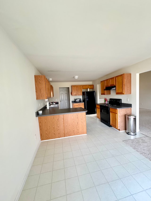 kitchen with black appliances, under cabinet range hood, dark countertops, a peninsula, and baseboards