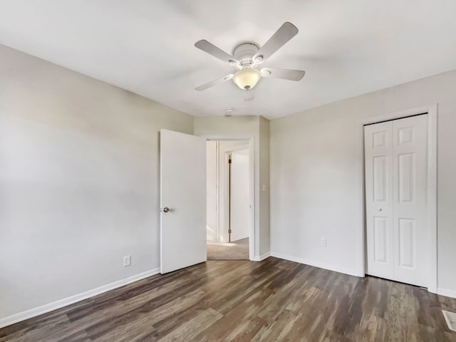 unfurnished bedroom with a ceiling fan, wood finished floors, a closet, and baseboards