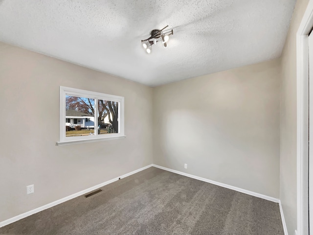 carpeted empty room with visible vents, baseboards, and a textured ceiling