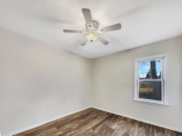 unfurnished room with a ceiling fan, baseboards, and dark wood-style flooring