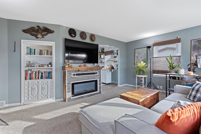 carpeted living room featuring a fireplace and baseboards