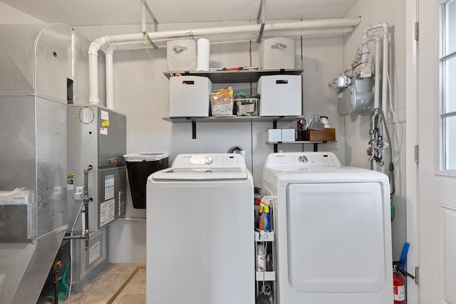 laundry area featuring heating unit, laundry area, and washing machine and clothes dryer