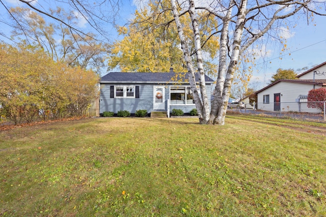 view of front of property with a front lawn and fence