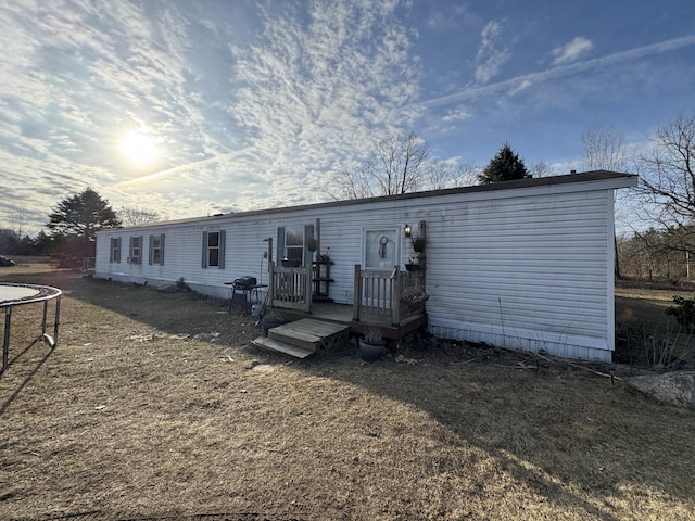 rear view of property featuring a trampoline