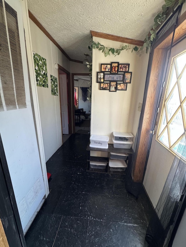 hall with crown molding, a heating unit, and a textured ceiling