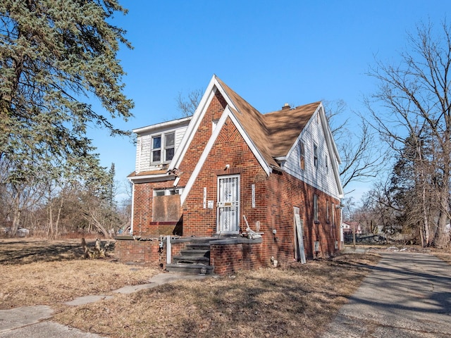 english style home with brick siding and aphalt driveway