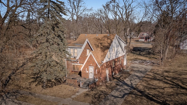 view of home's exterior with brick siding, an attached garage, and driveway