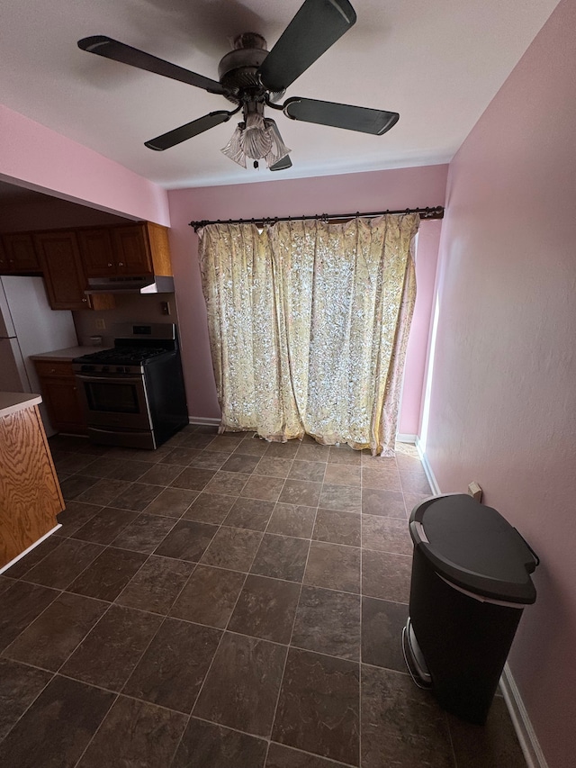 interior space featuring baseboards and ceiling fan