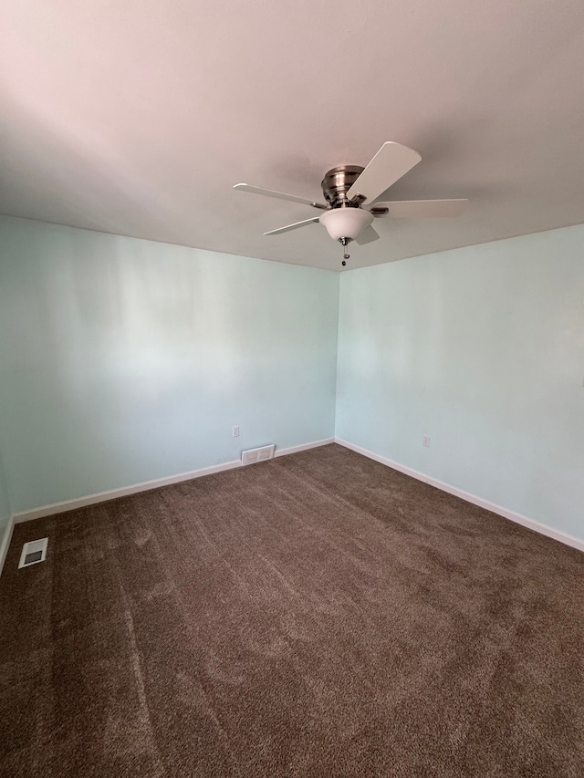 carpeted spare room with visible vents, baseboards, and a ceiling fan