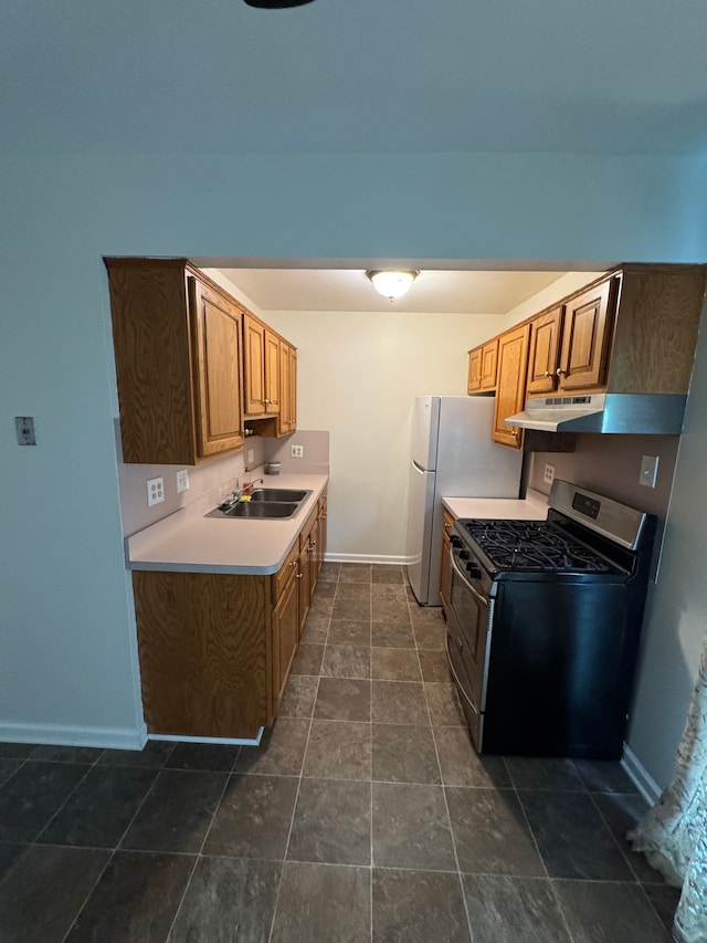 45577 Kensington St, Utica, MI 48317 - kitchen with gas stove, baseboards, light countertops, a sink, and under cabinet range hood
