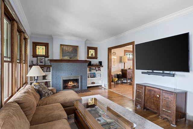 living room with dark wood-type flooring, a brick fireplace, and crown molding