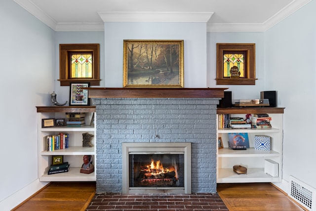 details featuring visible vents, wood finished floors, a fireplace, crown molding, and baseboards