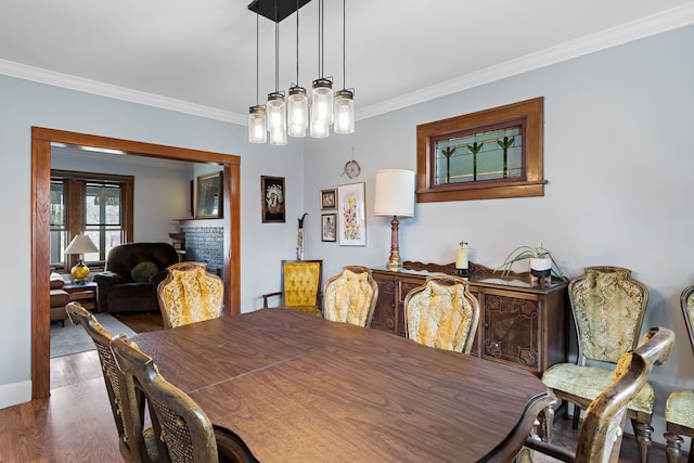 dining space with ornamental molding and wood finished floors