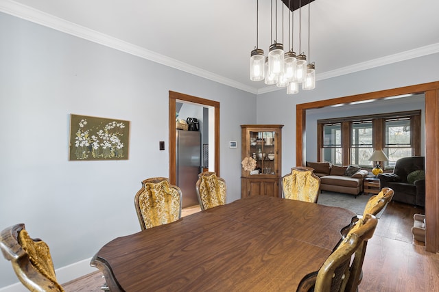 dining area featuring baseboards, a notable chandelier, wood finished floors, and crown molding