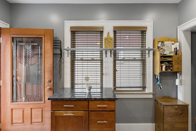 kitchen featuring dark stone countertops and brown cabinetry