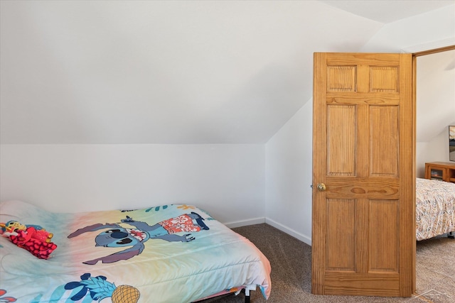 carpeted bedroom featuring lofted ceiling and baseboards