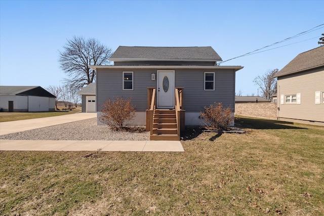 bungalow featuring a garage, driveway, a shingled roof, and a front lawn