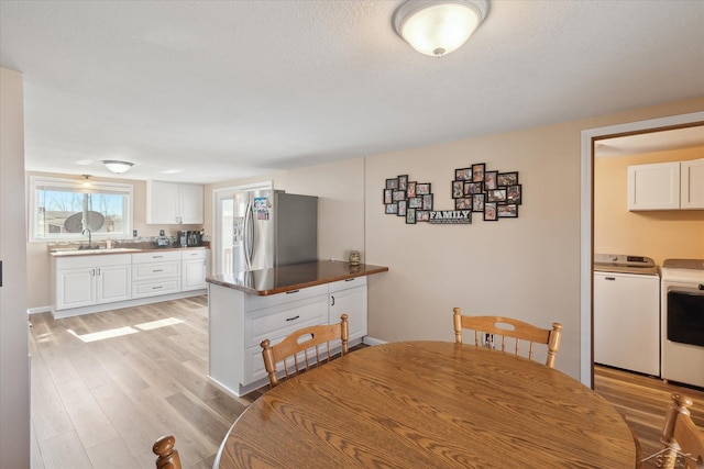 dining space with light wood finished floors and washing machine and clothes dryer