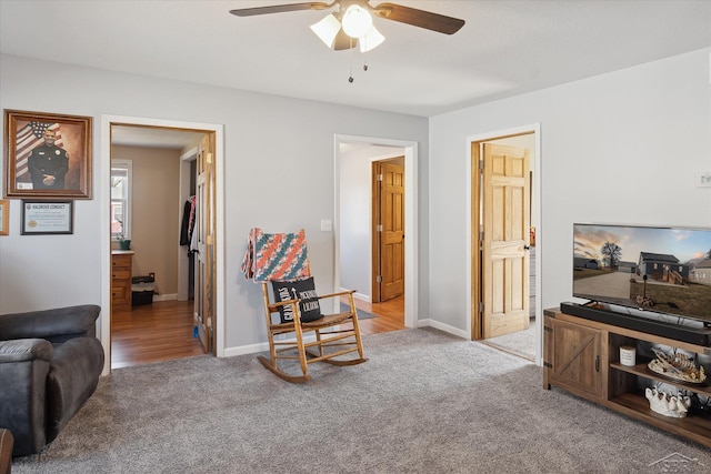 carpeted living room with baseboards and ceiling fan