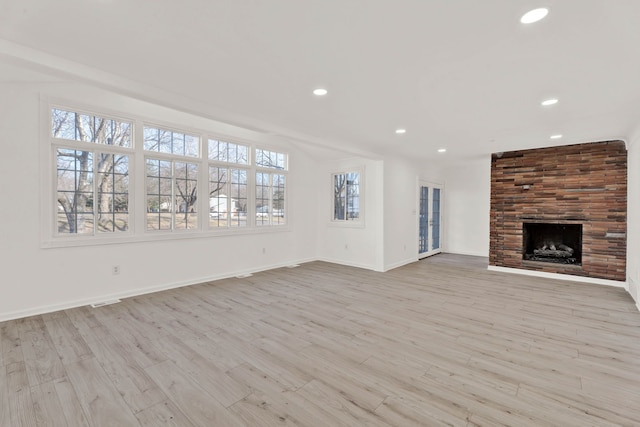 unfurnished living room featuring recessed lighting, a fireplace, baseboards, and wood finished floors