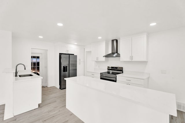 kitchen with a sink, stainless steel range with electric cooktop, wall chimney range hood, light wood-type flooring, and black refrigerator with ice dispenser