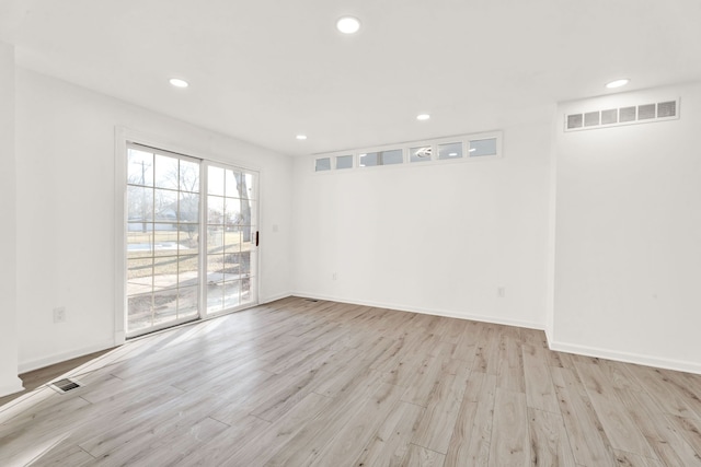 unfurnished room featuring recessed lighting, wood finished floors, visible vents, and baseboards