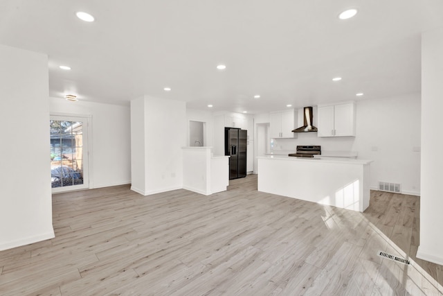 unfurnished living room with recessed lighting, visible vents, light wood-type flooring, and baseboards