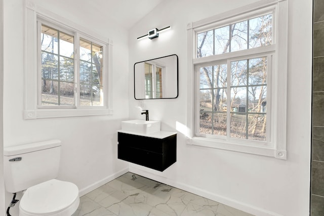 bathroom featuring vanity, baseboards, lofted ceiling, toilet, and marble finish floor