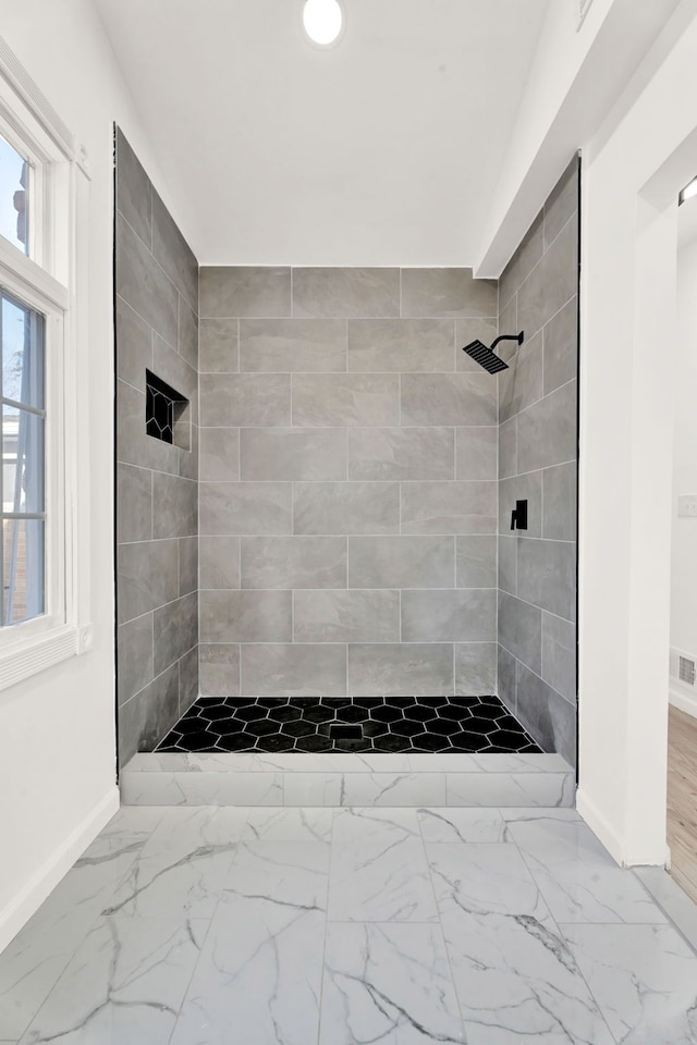 full bathroom featuring visible vents, baseboards, marble finish floor, and a tile shower