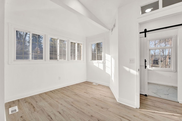 unfurnished sunroom featuring a barn door and visible vents