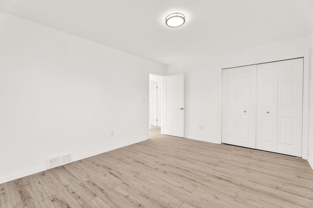 unfurnished bedroom with visible vents, baseboards, and light wood-style flooring