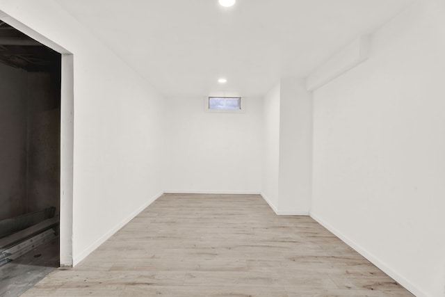 finished below grade area featuring recessed lighting, baseboards, and wood finished floors