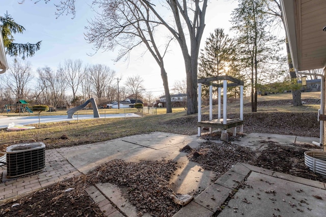 view of yard featuring central AC unit and playground community