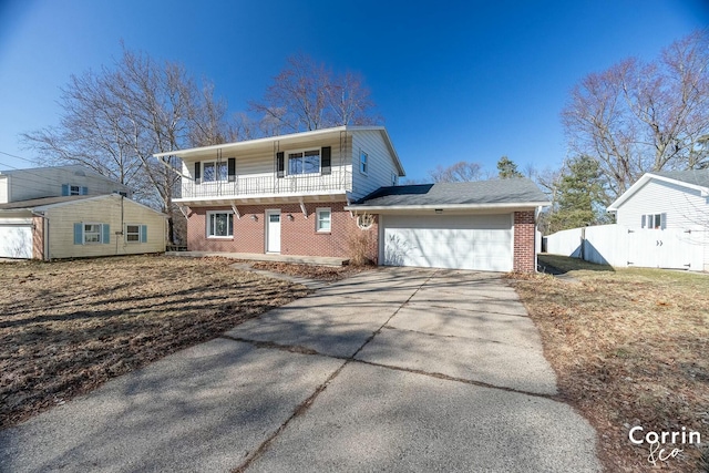 view of front of property with a balcony, fence, concrete driveway, a garage, and brick siding