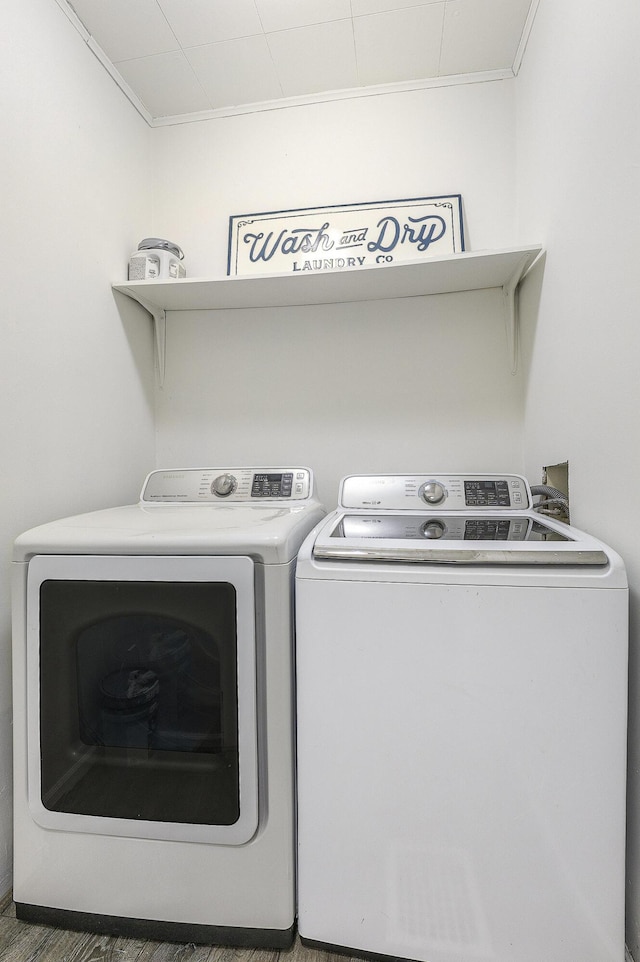 laundry room with laundry area, crown molding, and washing machine and clothes dryer