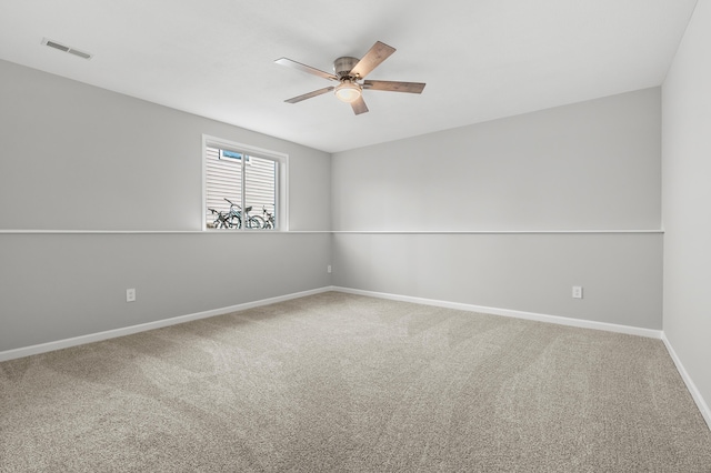 spare room with visible vents, baseboards, a ceiling fan, and carpet flooring