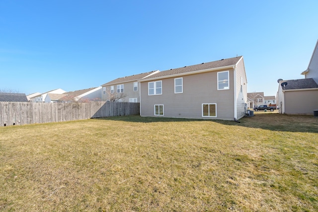 back of house with a lawn and fence