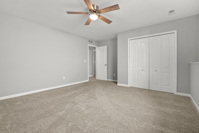 unfurnished bedroom with a closet, visible vents, baseboards, and carpet