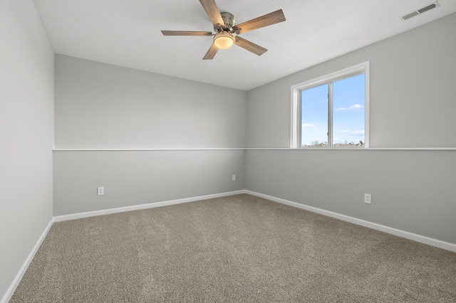 carpeted empty room with visible vents, baseboards, and a ceiling fan