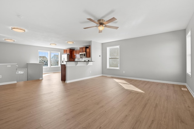 unfurnished living room with visible vents, baseboards, light wood-style floors, and a ceiling fan