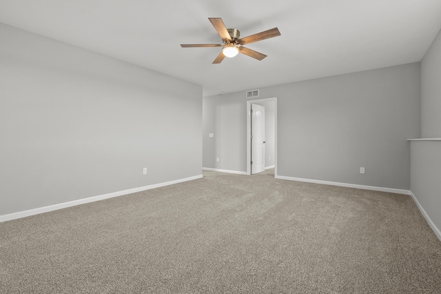 carpeted empty room with visible vents, a ceiling fan, and baseboards