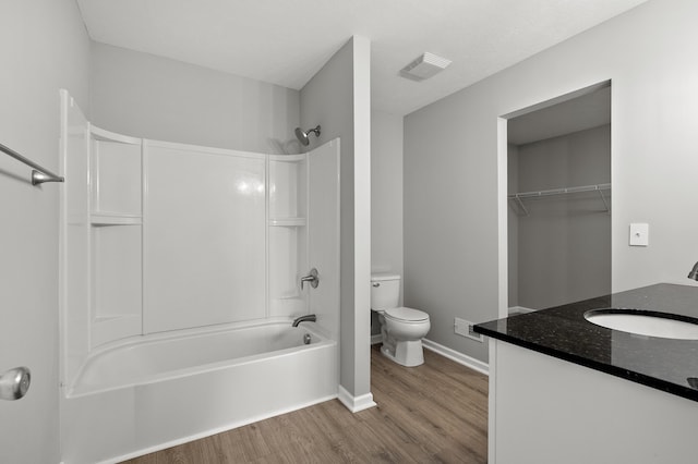 bathroom with toilet, shower / tub combination, wood finished floors, baseboards, and vanity