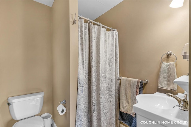 full bath featuring a shower with curtain, toilet, and a sink