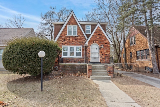 tudor house featuring brick siding