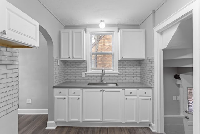 kitchen featuring dark wood-style floors, white cabinetry, and a sink