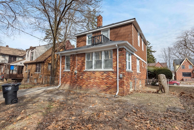 back of property with fence, brick siding, and a chimney